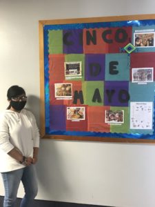 student standing next to cinco de mayo bulletin board